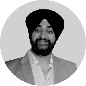 Alt text: Portrait of a smiling Sikh businessman in a turban, wearing formal suit. The monochrome image is set against a light grey backdrop in a circular frame by Jonas Construction Software.